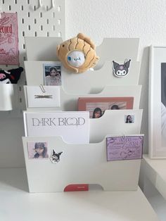 there is a white desk with many pictures and magnets on it