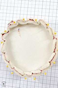 an unfinished pie crust with yellow and red beads