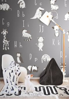 a child's room decorated in black and white with animal wallpaper on the walls