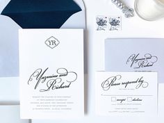 the wedding stationery is laid out on top of an envelope and some other items