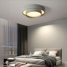 a bedroom with a large bed sitting under a round light above the headboard and foot board