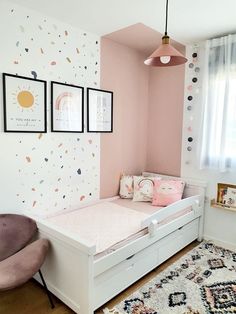 a small child's bedroom with pink walls and white furniture, including a toddler bed