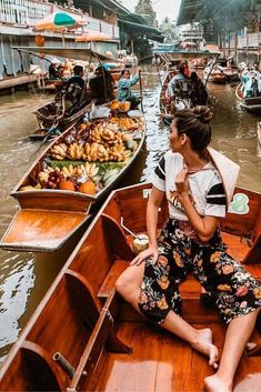 a woman sitting on the back of a boat filled with lots of people floating down a river