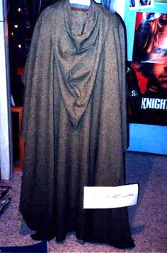 a batman costume on display in front of a movie poster