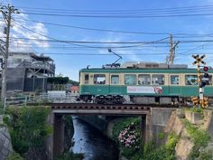 a green and white train traveling over a bridge