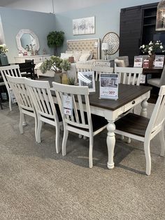 a table and chairs are on display in a room with other furniture at the store