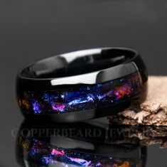 two black ceramic rings with blue and purple galaxy inlays on top of each other