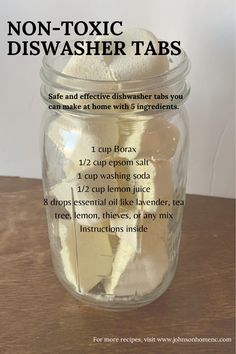 a glass jar filled with lemons on top of a wooden table