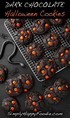 chocolate halloween cookies on a cooling rack with orange candies in the middle and black background