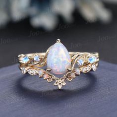 Nature Inspired  Jewelry, Twig Opal Ring Set , 10K Gold, Teardrop Ring, Branch Engagement Ring, Moonstone Wedding Ring , October Birthstone, Birthday Gifts Main Ring : 6*8mm Pear cut Lab white opal. Side stone : Moonstone Matching Band: Moissanite and opal. Material Metal: 925 sterling silver, Solid 14k/18k gold, platinum PLEASE choose silver or platinum if you are allergic to nickel. This jewelry is made to order, it can be made with any gemstone/metals. 2-3 weeks to finish. Default Shipping me Fairy Wedding Ring Opal, Topaz And Opal Ring, Real Opal Engagement Ring, Sun Ring Engagement, Opal Ring Set, Whimsical Wedding Ring Set, Opal And Aquamarine Ring, Pearl And Opal Engagement Ring, Mythical Engagement Ring