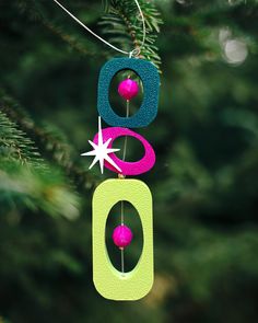 an ornament hanging from a christmas tree with two balls and stars on it