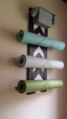 three yoga mats are hanging on the wall