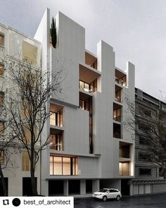 a white car parked in front of a tall building with balconies on it