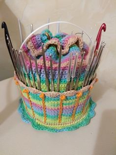 a crocheted basket with lots of forks and spoons sticking out of it