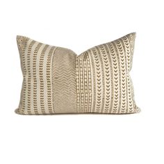 a beige and white pillow with an intricate design on it's front end,