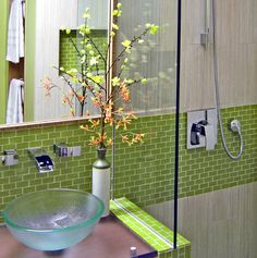 a green bathroom with a glass bowl sink