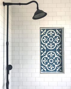 the shower head is next to a tiled wall