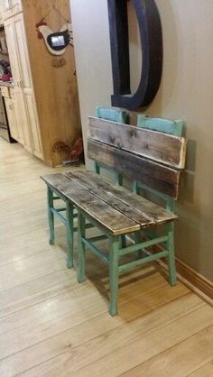 a wooden bench sitting in front of a wall with a large d sign on it