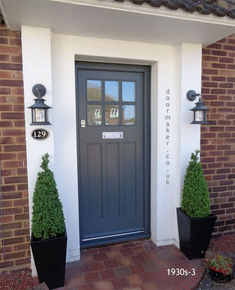 a blue front door with two black planters