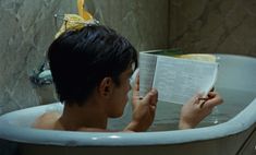 a man reading a book in a bathtub