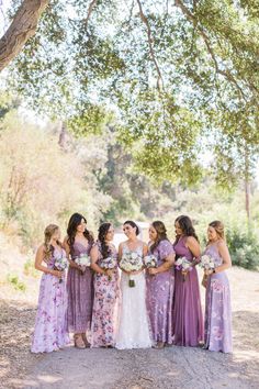 a group of women standing next to each other under a tree