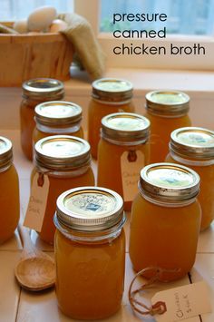 there are many jars with some food in them on the table and one has a label that says pressure canned chicken broth