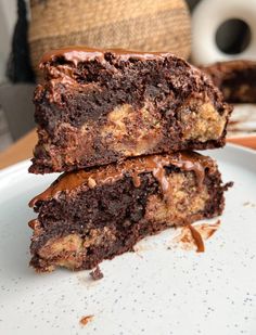 two pieces of chocolate cake sitting on top of a white plate