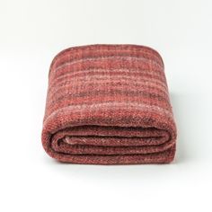 a red blanket folded on top of a white surface