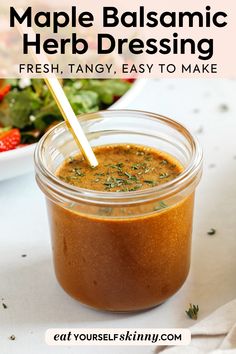 a jar filled with homemade balsamic herb dressing next to a bowl of salad