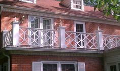 a red brick house with white balconies and windows