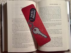 an open book with a red case and a key on the cover that is attached to it