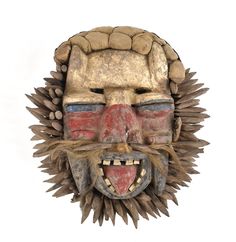 a wooden mask with spikes on it's face