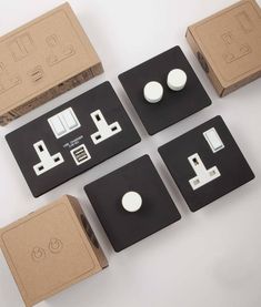 four different types of electrical plugs and sockets in cardboard boxes on a white surface