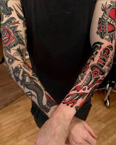 a man with many tattoos on his arms and hands, both holding each other's hands