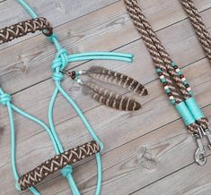 three pieces of rope with beads and feathers attached to them on a wooden table next to scissors