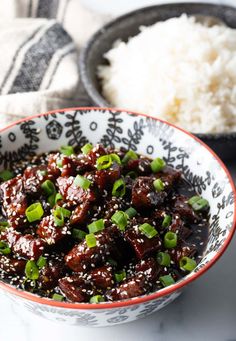 a bowl filled with meat and rice on top of a table