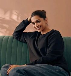 a woman sitting on top of a green couch