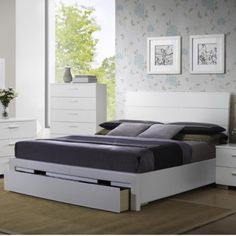 a white bed sitting in a bedroom next to a dresser with drawers on top of it