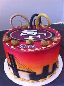 a cake that is decorated with the san francisco giants logo and gold scissors on top