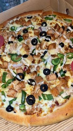 a pizza sitting on top of a box covered in cheese and veggie toppings