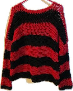 a red and black sweater hanging on a clothes hanger with the top half turned down