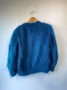 Vintage Alain Murati Ocean Blue Fuzzy Sweater Cardigan. Absolutely stunning ocean blue sweater with two toned teal and blue embroidery designs. Floral designs scatter across the front with a big personality. Inner lining has subtle impressions that only adds to the charm of this statement piece. In excellent vintage condition. Mohair blend. Unmarked size, material is stretchy. Fits a M/L . Hand wash cold. Approx. Measurements: Length: 26" Underarm to underarm: Up to 30" Blue Long Sleeve Winter Cardigan, Blue Long Sleeve Cardigan For Winter, Winter Blue Sweater For Layering, Blue Winter Cardigan For Layering, Blue Cardigan For Winter Layering, Blue Crew Neck Cardigan For Winter, Blue Long Sleeve Sweater For Layering, Blue Crew Neck Cardigan For Fall, Turquoise Long Sleeve Winter Outerwear