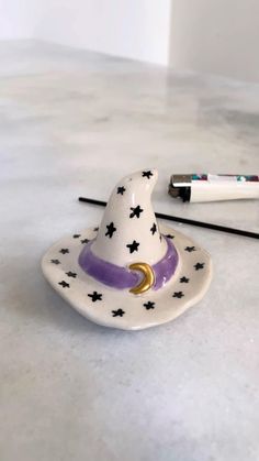 a ceramic witch hat sitting on top of a table next to a marker and pen