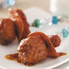 two meatballs covered in sauce on a white plate