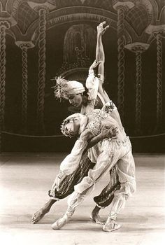 two people are performing an artistic dance on stage