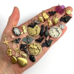 a person's hand holding many different types of charms