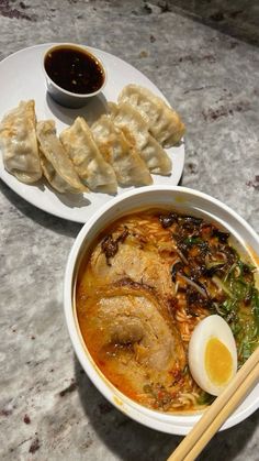 a bowl of ramen with chopsticks next to it