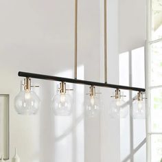 a light fixture hanging from the ceiling in a room with white walls and flooring