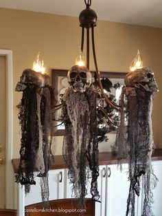 a chandelier decorated with black lace and skulls hanging from it's arms