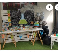 an image of a party table with balloons and desserts on the table in front of it